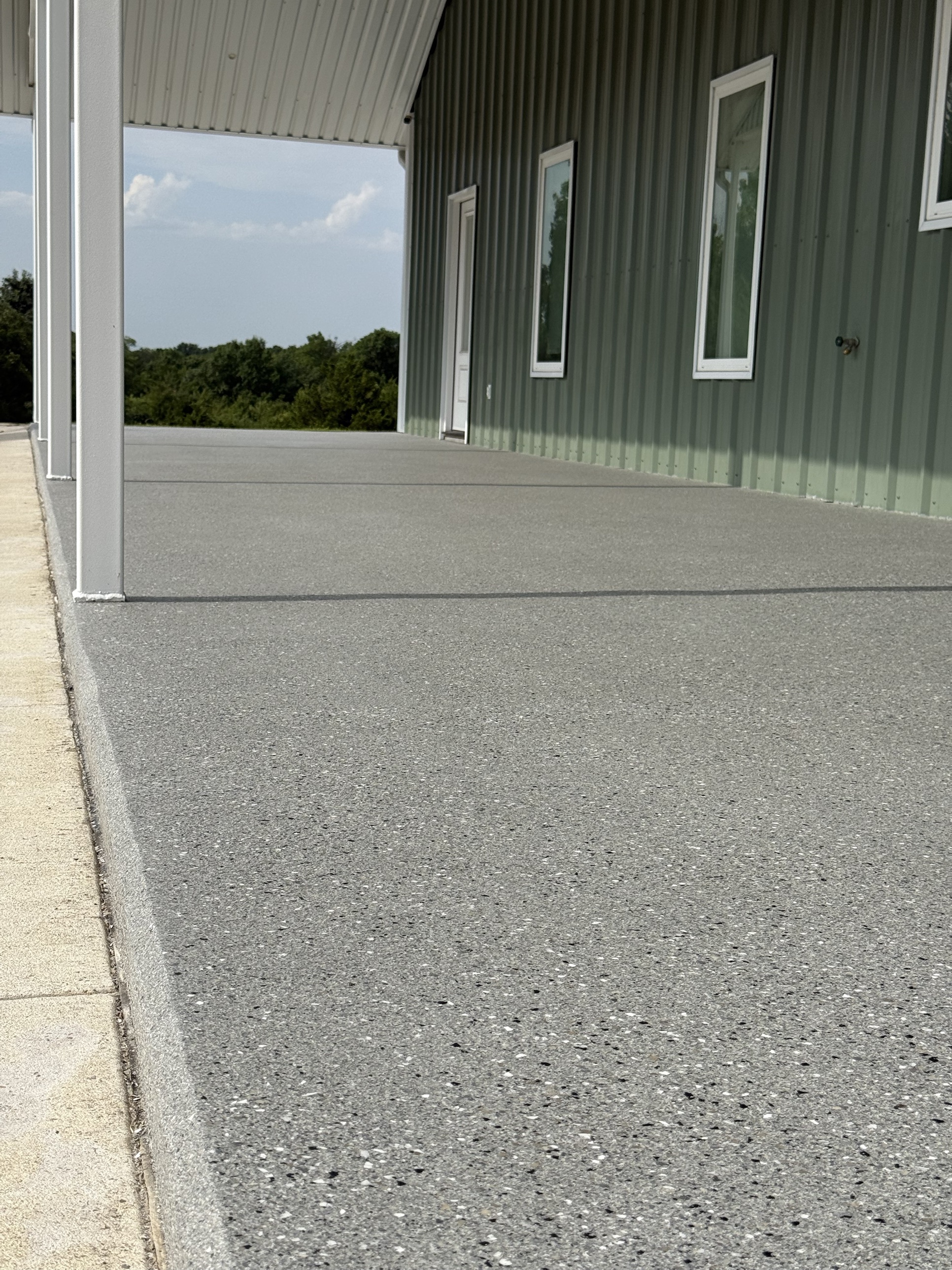 Shale patio floor along the side of a metal shop building